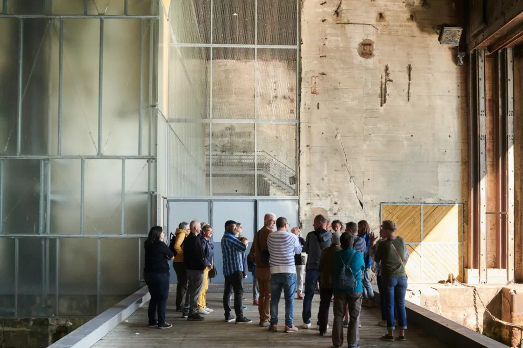 Photographie d'un groupe de visiteurs lors d'une visite guidée dans la base sous-marine de Saint-Nazaire.