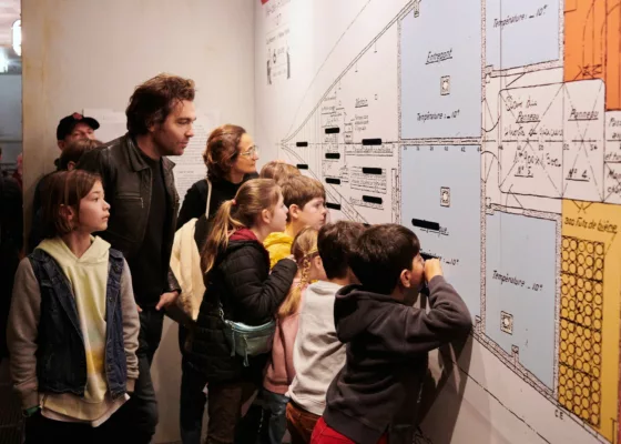 Groupe de visiteurs adultes et enfants dans Escal'Atlantic lors d'une visite guidée.