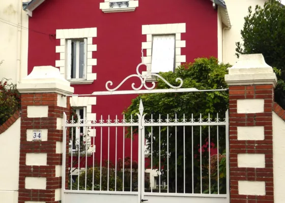 Photographie en couleur d'une maison rouge typique de l'architecture de la Belle Époque.