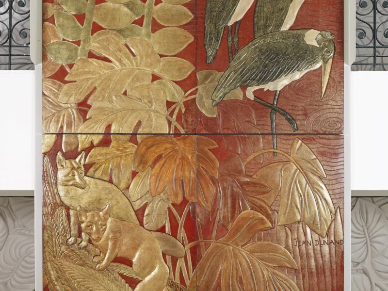 Ensemble de panneaux de laque intitulé "La Chasse", qui décore la porte coulissante séparant le fumoir du grand salon de première classe du paquebot Normandie (1935). Deux renards et trois marabouts dans une végétation sont représentés.