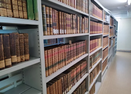 Photographie en couleur d'une travée de livres anciens dans les réserves de la médiathèque Étienne Caux à Saint-Nazaire.