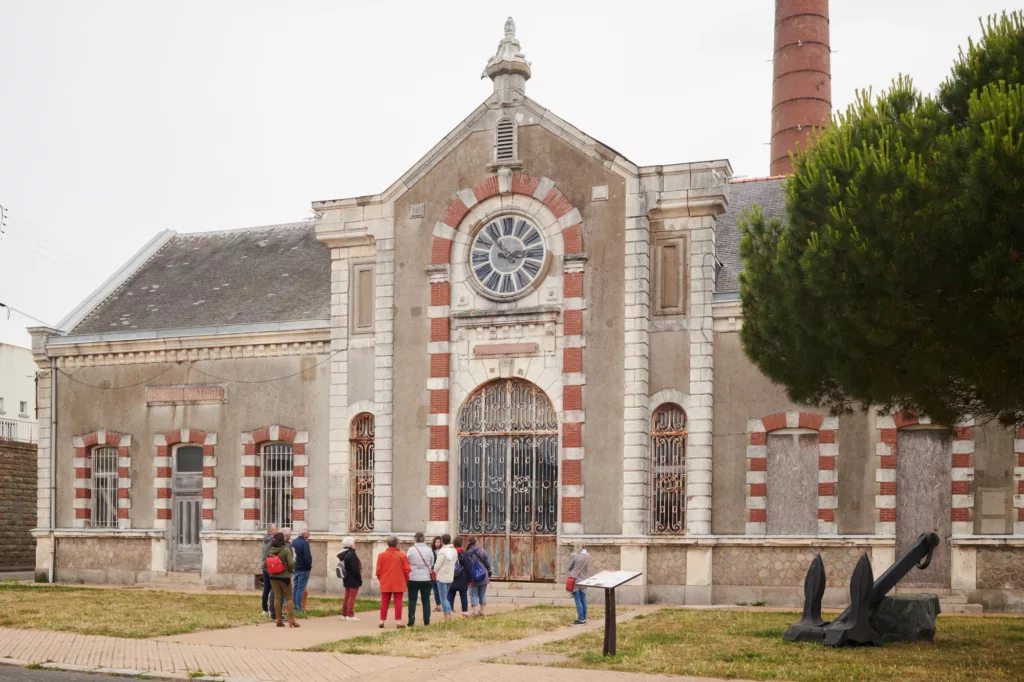 Photographie d'un groupe de visiteurs devant l'ancienne usine élévatoire.