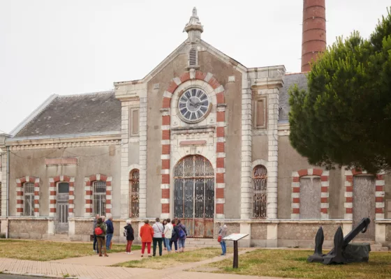 Photographie d'un groupe de visiteurs devant l'ancienne usine élévatoire.