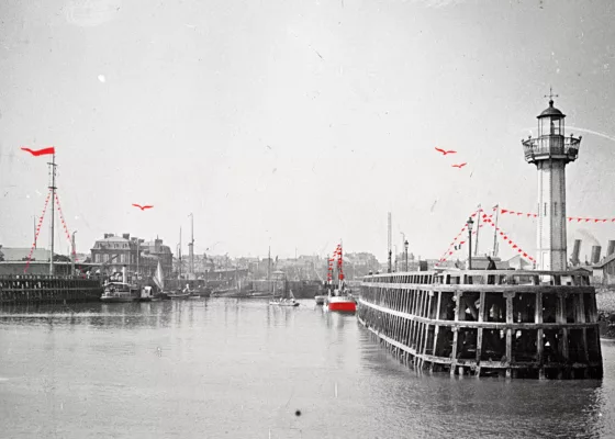 Photographie ancienne en noir et blanc représentant l'entrée est du port de Saint-Nazaire avec à droite l'estacade et son feu de signalisation.