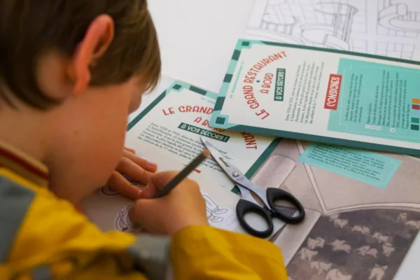 Enfant de dos en train de dessiner pendant le jeu « Le grand restaurant à bord, à vos décors ! ».