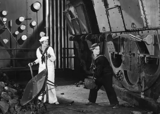 Image provenant du film "La croisière du Navigator" de Buster Keaton et Donald Crisp représentant Kathryn McGuire et Buster Keaton dans les soutes à charbon d'un paquebot.